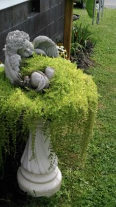 a white vase filled with green plants next to a building