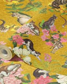 a roll of tape with cats and flowers on it next to a yellow wallpaper