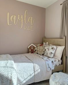 a bed room with a neatly made bed and a large wall decal on the wall