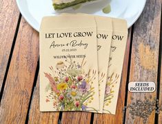 three seed packets sitting on top of a white plate next to a slice of cake