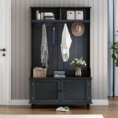 an entryway with a coat rack, hat and flowers