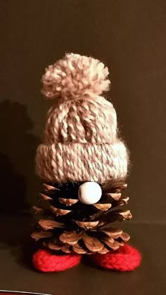 a knitted pine cone with a white ball on top and red wool slippers