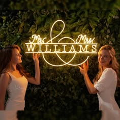 two women standing next to each other in front of a sign that says mr and mrs williams