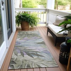 a porch with a rug and potted plants on it