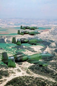 four fighter jets flying in formation over the desert