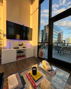 a living room filled with furniture and a flat screen tv mounted to the side of a wall