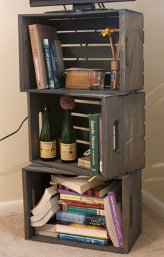 a tv sitting on top of a wooden shelf filled with books and wine bottles next to a wall