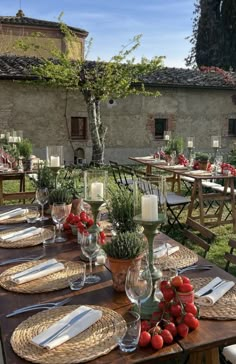 an outdoor table set with place settings for dinner