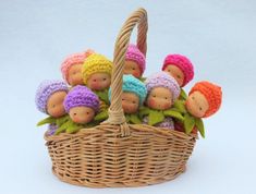 a basket filled with small knitted dolls sitting next to each other