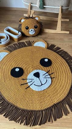 a crocheted lion rug with two stuffed animals on the floor