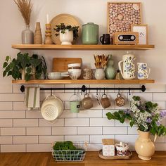 the shelves above the kitchen counter are filled with pots, pans and other items