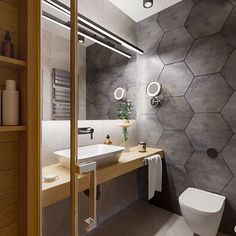 a modern bathroom with hexagonal tiles on the wall and wooden countertop, along with a white toilet