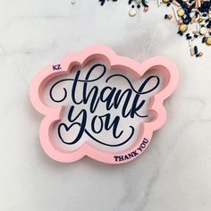 a thank you sticker sitting on top of a table next to confetti