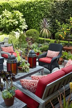 an outdoor seating area with red cushions and potted plants