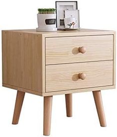 a small wooden table with two drawers and a potted plant sitting on top of it