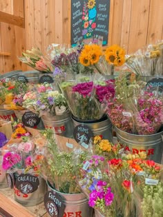 several buckets filled with flowers sitting on top of a table