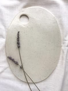 a white platter with lavender sprigs on it and a round cutting board