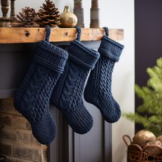 two knitted christmas stockings hanging from a mantel