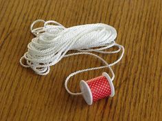 two spools of thread are sitting on the table next to a red and white cup