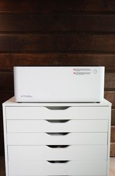 a white filing cabinet sitting on top of a wooden floor