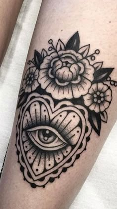 a woman's leg with an eye and flower tattoo on it