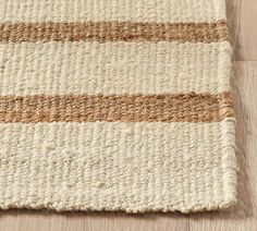 an area rug on the floor that has been made with natural materials and is beige and brown