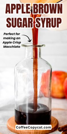 an apple brown sugar syrup is being poured into a glass carafe with cinnamon sticks