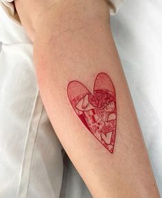 a person with a tattoo on their arm has a heart shaped piece of pizza in it