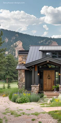 a house in the mountains with a large wooden front door and stone steps leading up to it