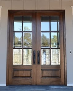 two double doors with sidelights and windows on the outside of a house in front of an entry door