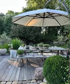 an outdoor dining area with tables, chairs and umbrellas in the middle of it