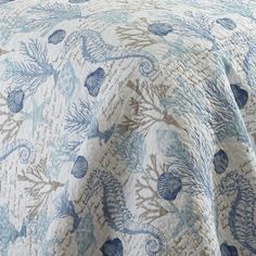 a blue and white bedspread with sea shells on it