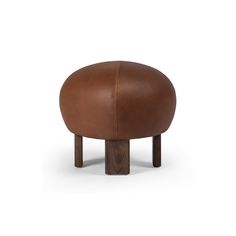 the foot stool is made out of brown leather and has wooden legs, with a round shaped