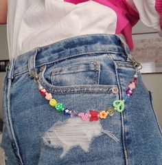 the back of a woman's jean shorts with colorful beads and charms on it