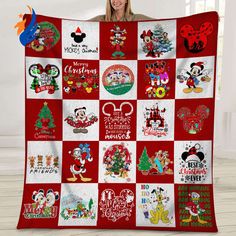 a woman holding up a mickey mouse christmas quilt