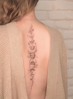 the back of a woman's shoulder with flowers and leaves on her left side