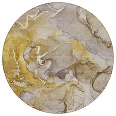 a round rug with an abstract design in gold and grey tones on a white background