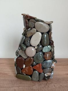 a vase made out of rocks on a wooden table