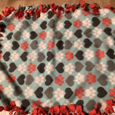 a dog paw print blanket with red bows on it's edges and the top part of the blanket is made out of fabric