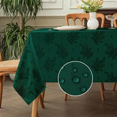 a green table cloth with water drops on it and a vase full of flowers in the background