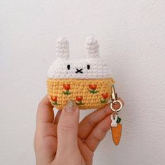 a hand holding a small crocheted keychain shaped like a food item