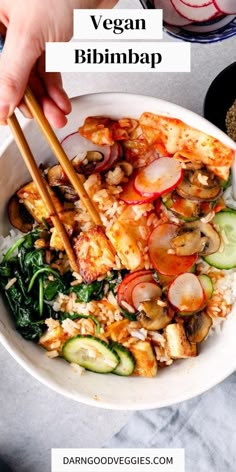 vegan bibimba with chopsticks in a bowl filled with rice and vegetables