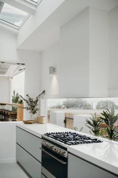 a kitchen with an oven, stove and dining room table in the backround