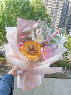 a person holding a bouquet of flowers in their hand