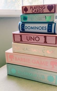 stack of books sitting on top of each other in front of a window with the words dominos uno written on them