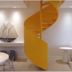 a yellow spiral staircase in a white room