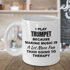 a white coffee mug that says i play trumpet because making music is a lot more fun than going to therapy