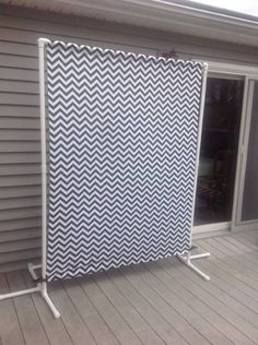 a white and black screen sitting on top of a wooden floor next to a window