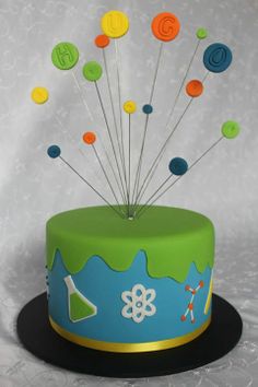 a birthday cake decorated with colorful buttons and a sprinkler on the top