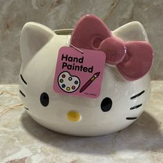 a hello kitty piggy bank with a pink bow on it